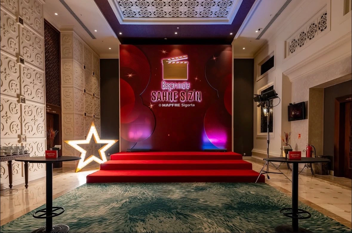 Red-carpet photo stage with branded MAPFRE Sigorta backdrop and illuminated star for guests at the Antalya event