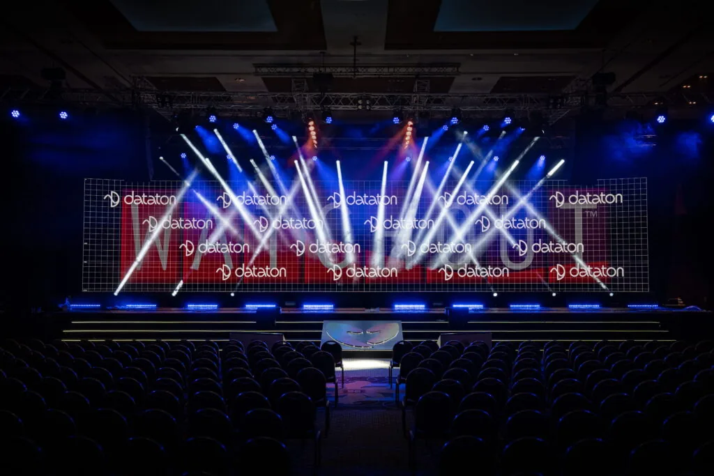 Corporate event stage with full-width LED wall and moving-light beam show in a ballroom, Türkiye