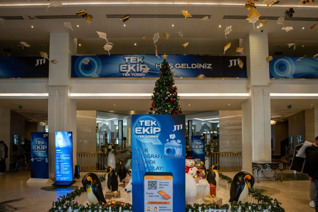 Hotel lobby branded with overhead banners, totems and seasonal décor for a JTI “Tek Ekip” event, Türkiye