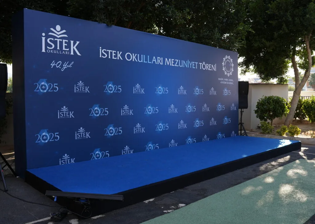 Step-and-repeat photo wall on a raised platform for the İSTEK Schools graduation ceremony in Antalya
