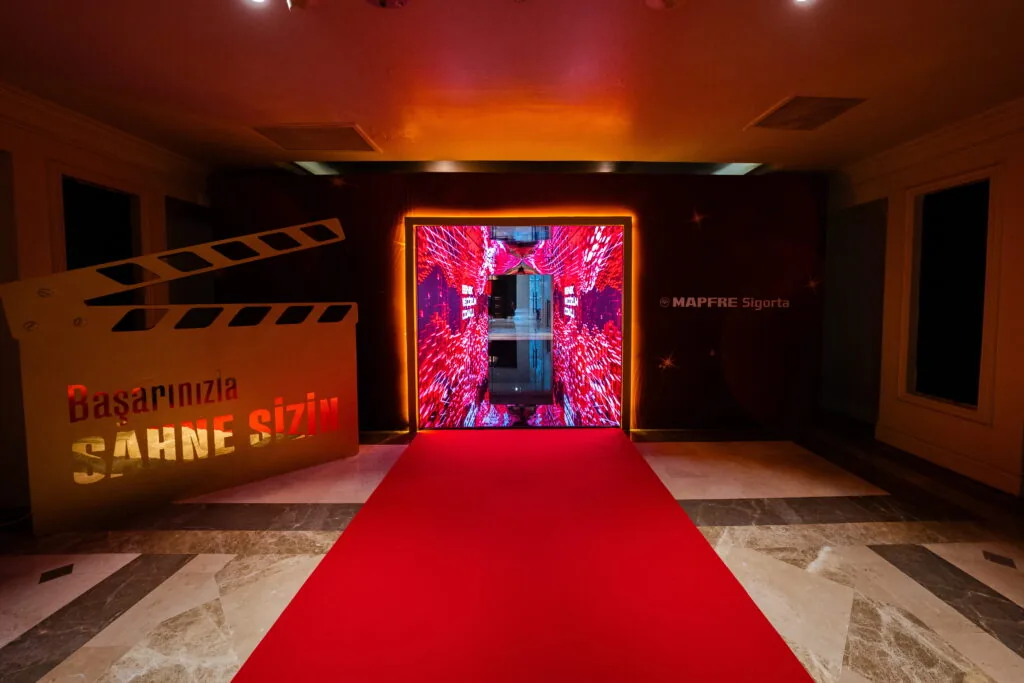 Red-carpet entrance leading to an LED-framed doorway at the MAPFRE Sigorta event in Antalya