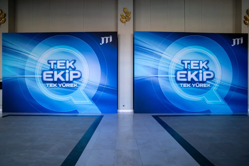 Twin stretch-fabric backdrops with “Tek Ekip Tek Yürek” graphics for a JTI meeting, Türkiye