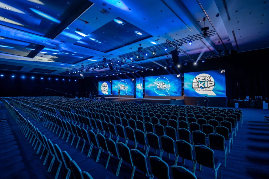 Theatre-style ballroom with LED screens and lighting rig for a JTI “Tek Ekip” meeting, Türkiye