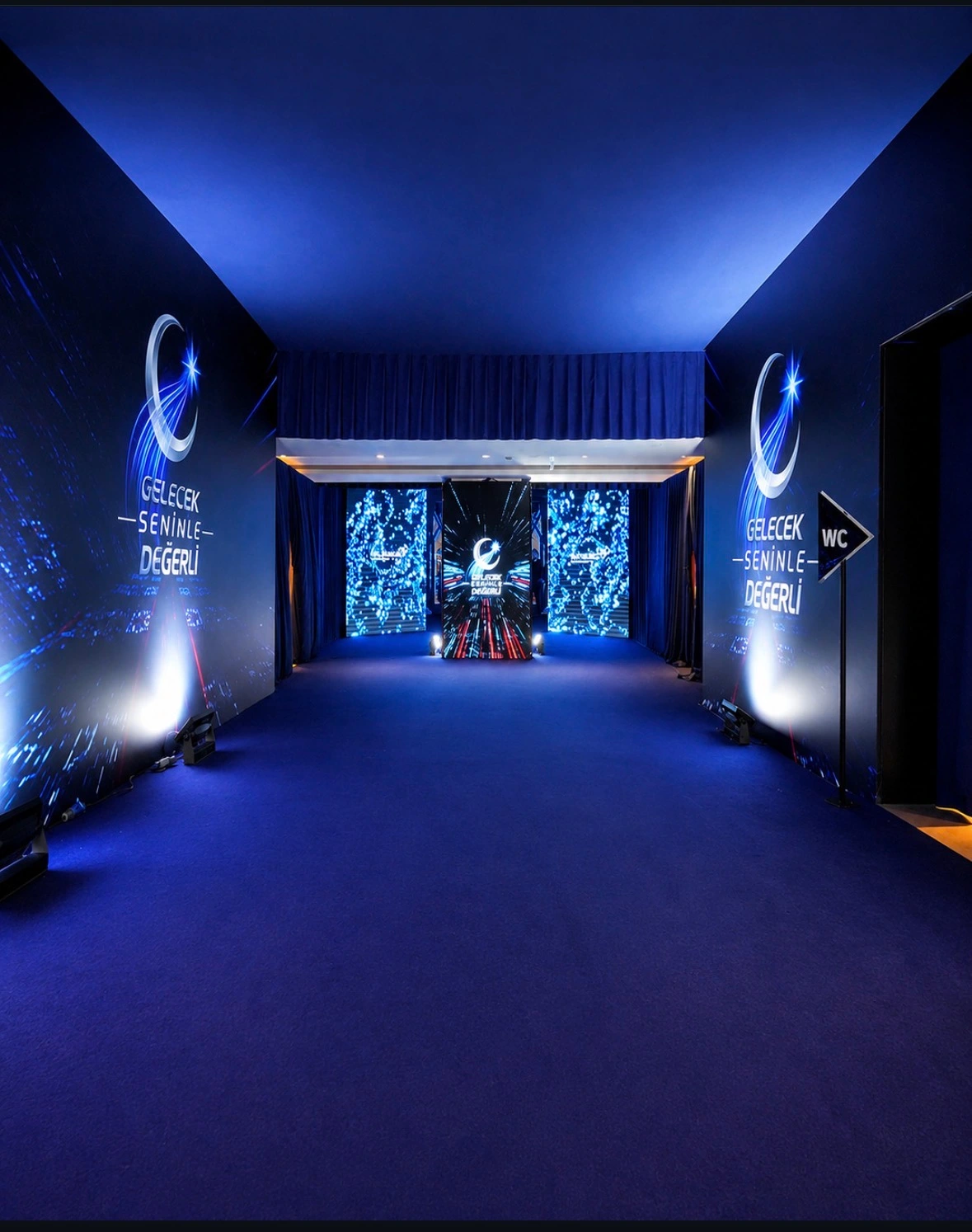 Blue branded corridor with Türk Telekom campaign panels leading to the meeting hall at Rixos Sungate